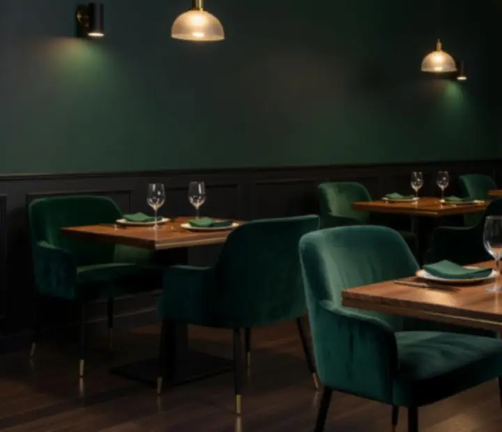 Mood-lit bistro dining room with raw wood fixtures and emerald tones at Theturnandtable